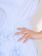 NEWYORKLISTED RUNWAY STYLE: Close-up of a hand touching a textured blue and white striped fabric