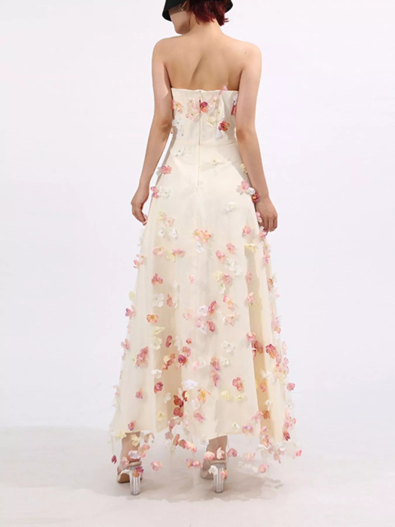 NEWYORKLISTED STYLE COLLECTION: Woman wearing a strapless floral gown on a white background