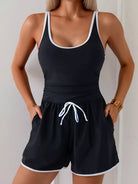 NEWYORKLISTED STYLE COLLECTION: Person wearing a black tank top and shorts with white trim against a plain background