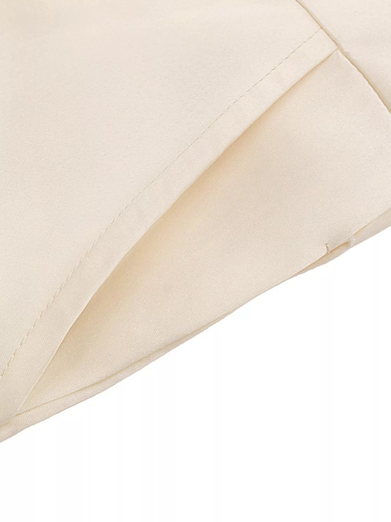 Close-up of a beige quilted fabric corner on a white background