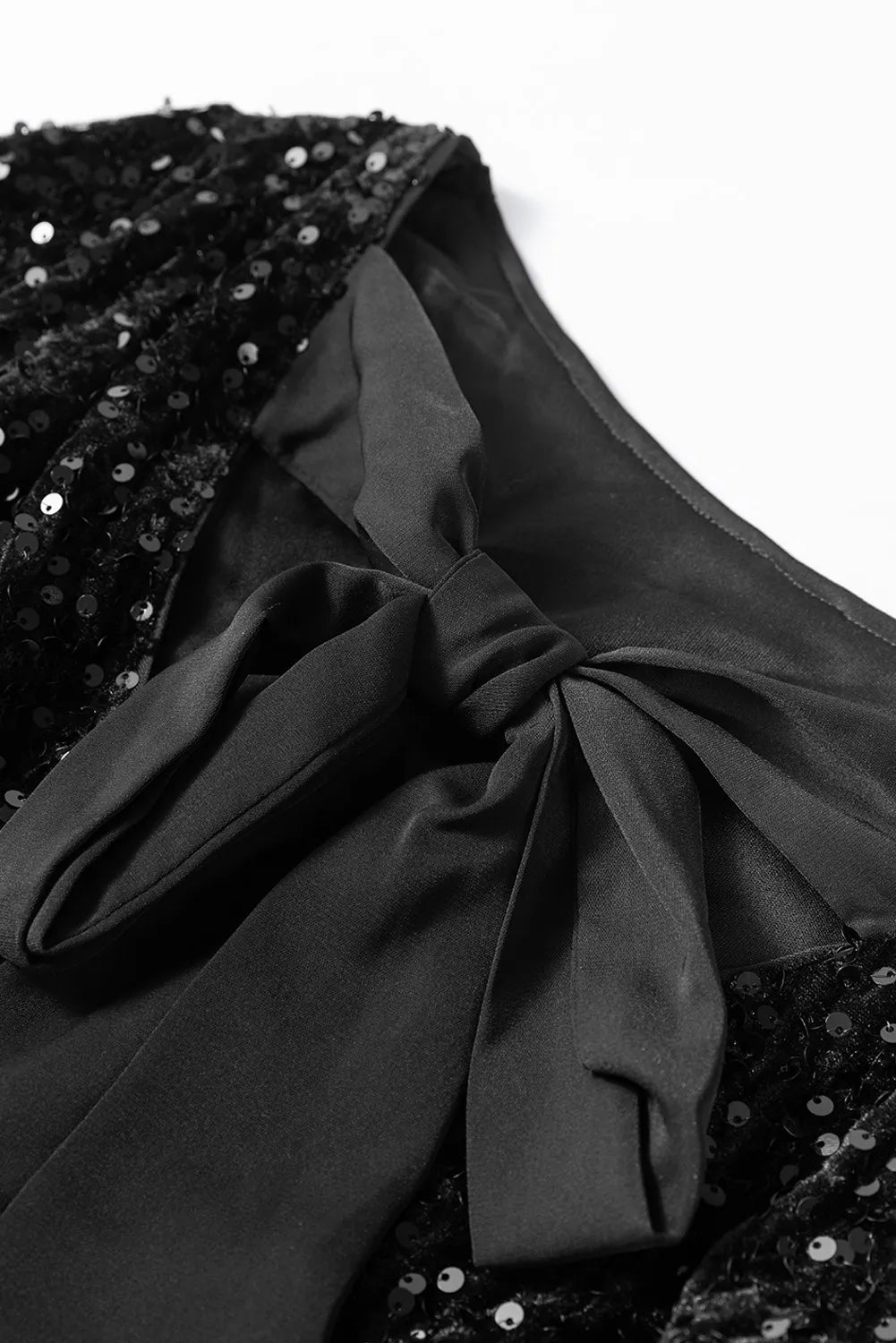 NEWYORKLISTED Valentine's Day Specials: Black sequined dress with a large bow detail on a white background