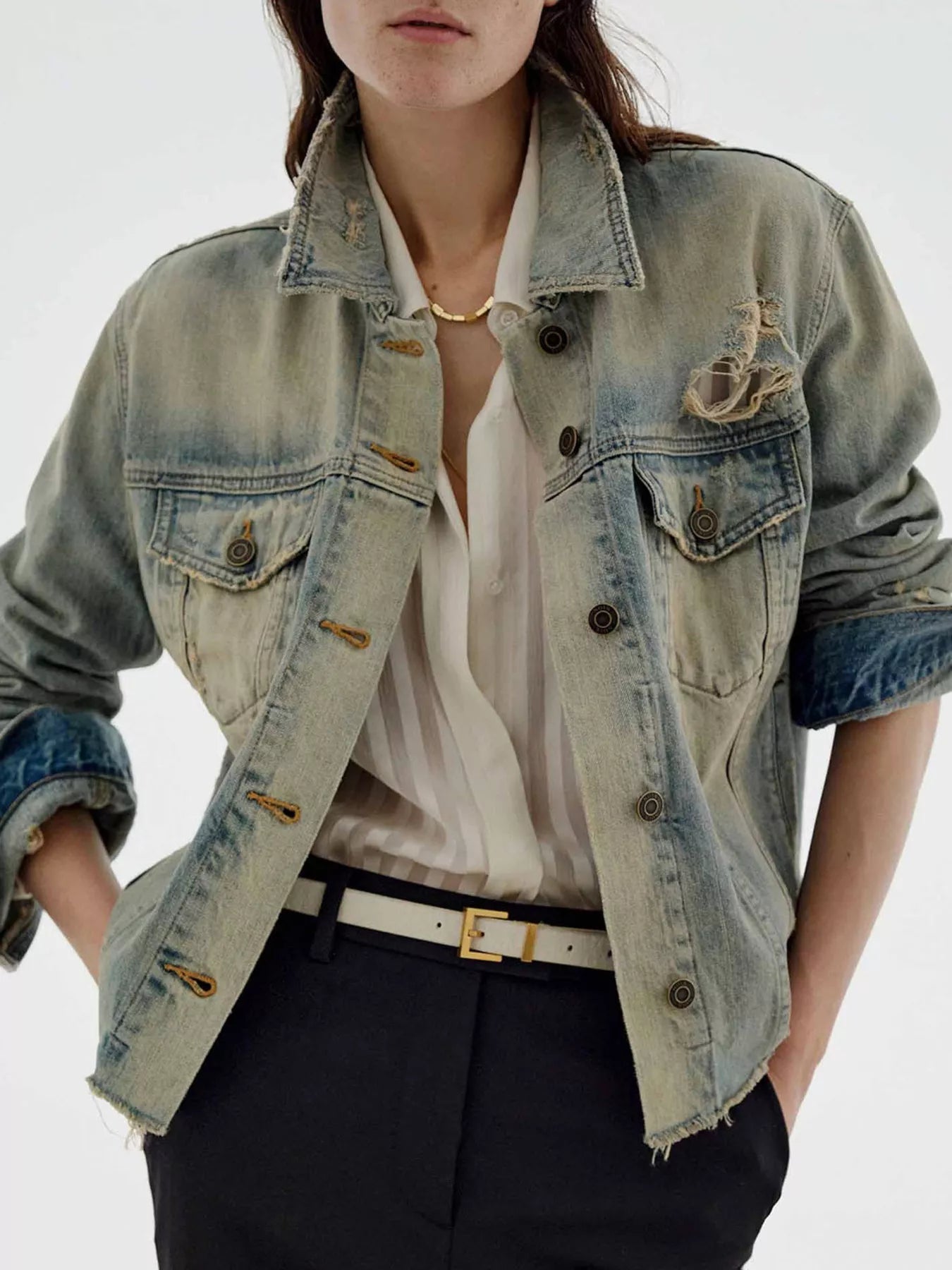 NEWYORKLISTED STYLE COLLECTION: Person wearing a light blue denim jacket over a white shirt with a plain background